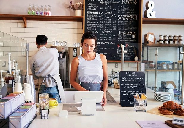 Couple working behind the counter at a coffee shop
